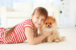 Cute girl with little dog on floor at home