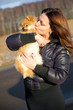 Young attractive girl kissing puppy spitz dog with love.